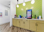 Thumbnail 8 of 75 - A kitchen with a green wall and wooden cabinets.
