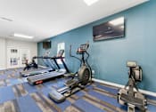 Thumbnail 26 of 75 - A gym with treadmills, exercise bikes, and other equipment.