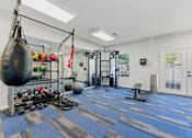 Thumbnail 24 of 75 - A gym with a punching bag, weights, and exercise equipment.