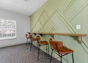 Thumbnail 46 of 75 - A room with green walls and a wooden shelf with chairs.