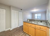 Thumbnail 29 of 35 - an empty kitchen with a sink and wooden cabinets at Crogman School Lofts, Atlanta, 30315