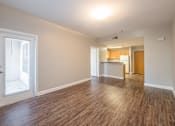 Thumbnail 28 of 35 - the living room and kitchen of an apartment with wood flooring and a large window at Crogman School Lofts, Atlanta, 30315