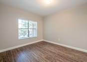 Thumbnail 33 of 35 - an empty living room with wood floors and a window at Crogman School Lofts, Atlanta, 30315
