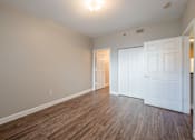 Thumbnail 35 of 35 - an empty living room with wood flooring and white doors at Crogman School Lofts, Atlanta, GA
