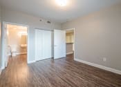 Thumbnail 34 of 35 - an empty living room with wood flooring and a bathroom at Crogman School Lofts, Georgia