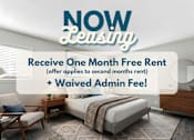 Thumbnail 1 of 45 - A room with a bed, chair, and table is advertised for leasing with a free first month and waived admin fee.