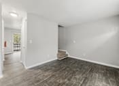 Thumbnail 34 of 35 - Room with wooden floor and carpeted staircase at Pinewood Townhomes, Tucker, 30084