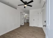 Thumbnail 15 of 28 - a living room with white walls and a ceiling fan