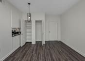 Thumbnail 10 of 34 - A room with a wooden floor and white walls.