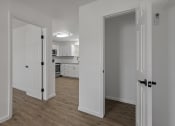 Thumbnail 26 of 28 - a renovated living room and kitchen with white walls and wood flooring