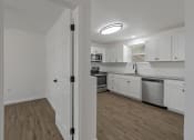 Thumbnail 3 of 28 - an empty kitchen with white cabinets and stainless steel appliances
