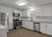 Thumbnail 25 of 28 - an empty kitchen with white cabinets and stainless steel appliances