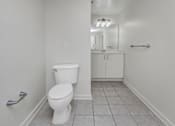 Thumbnail 14 of 34 - A white toilet in a bathroom with a white cabinet and a mirror.