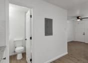 Thumbnail 20 of 28 - an open bathroom and living room with a toilet and a ceiling fan