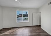 Thumbnail 9 of 34 - A room with a window showing a view of a cityscape.