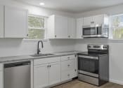 Thumbnail 23 of 28 - a kitchen with white cabinets and stainless steel appliances