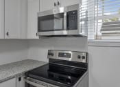 Thumbnail 24 of 28 - a kitchen with a stove and a microwave