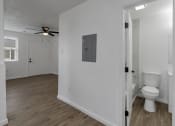 Thumbnail 10 of 28 - an open bathroom and living room with a toilet and a ceiling fan
