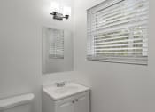 Thumbnail 13 of 28 - a bathroom with a sink and a mirror and a window