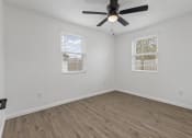 Thumbnail 19 of 28 - an empty room with a ceiling fan and two windows