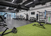 Thumbnail 43 of 47 - A gym with a variety of equipment including a rowing machine, weights, and a bench press.