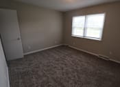 Thumbnail 33 of 39 - A room with a carpeted floor and a window.