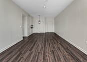Thumbnail 26 of 34 - A room with wooden flooring and white walls.
