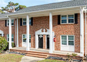 Thumbnail 13 of 30 - A red brick house with a black door and white columns.