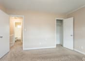 Thumbnail 6 of 30 - A room with a carpeted floor and white walls.