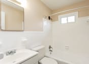 Thumbnail 26 of 30 - A white toilet sits next to a sink in a bathroom.