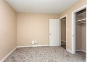 Thumbnail 15 of 30 - A room with a white door and carpeted floor.