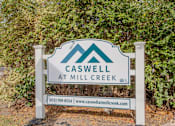 Thumbnail 9 of 30 - A sign for Caswell at Mill Creek stands in front of a green hedge.