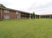 Thumbnail 26 of 29 - a large green lawn in front of a brick building