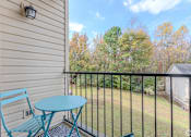 Thumbnail 10 of 25 - A balcony with a blue chair and table.