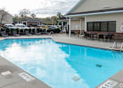 Thumbnail 20 of 25 - A swimming pool with a building in the background.