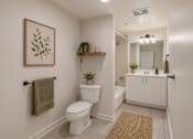 Thumbnail 4 of 34 - A bathroom with a toilet, a mirror, and a plant.