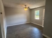 Thumbnail 24 of 27 - a empty living room with a ceiling fan and a window
