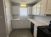 Thumbnail 23 of 27 - an empty kitchen with white cabinets and a sink