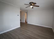 Thumbnail 11 of 29 - an empty living room with wood floors and a ceiling fan