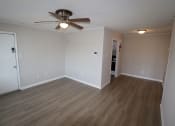 Thumbnail 12 of 29 - an empty living room with wooden floors and a ceiling fan