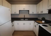 Thumbnail 9 of 29 - an empty kitchen with white cabinets and a sink