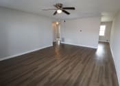 Thumbnail 4 of 29 - an empty living room with wooden floors and a ceiling fan
