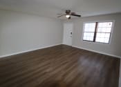 Thumbnail 5 of 29 - an empty living room with wooden floors and a ceiling fan