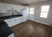 Thumbnail 2 of 29 - an empty kitchen with white cabinets and wood floors