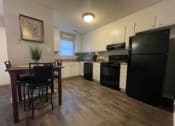 Thumbnail 1 of 27 - a kitchen with black appliances and a table and chairs