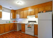 Thumbnail 17 of 27 - a kitchen with white appliances and wooden cabinets