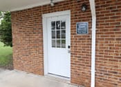 Thumbnail 17 of 29 - a brick building with a white door and a sign that says laundry room