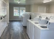 Thumbnail 21 of 29 - an empty laundry room with white washing machines
