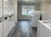 Thumbnail 19 of 29 - an empty kitchen with white appliances and a wood floor