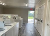 Thumbnail 18 of 29 - an empty laundry room with washing machines and sinks